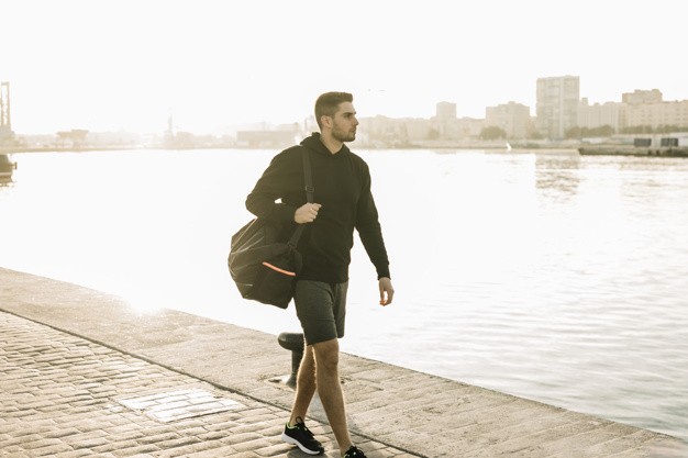 sportowiec z torbą na ramieniu idzie na siłownie