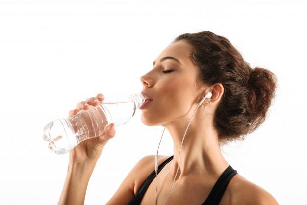 wysportowana kobieta pije wode z butelki