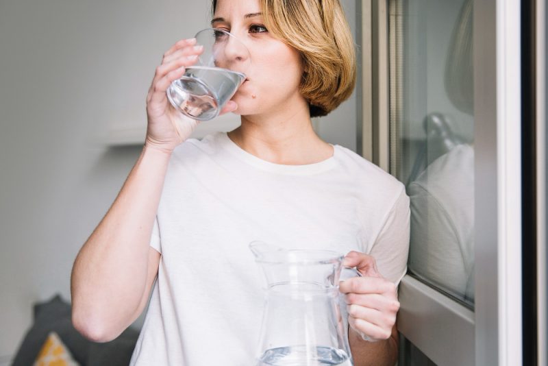 kobieta pije wode ze szklanki